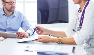 Doktor kıdemli hastaya ilaç yazar.