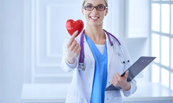 Doctora con el estetoscopio sosteniendo el corazón — Foto de Stock