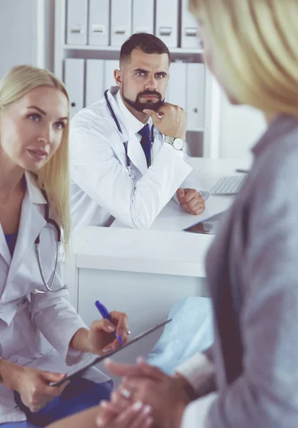 医者と患者はテーブルに座って何かを話し合う。医療・ヘルスケアの概念 — ストック写真