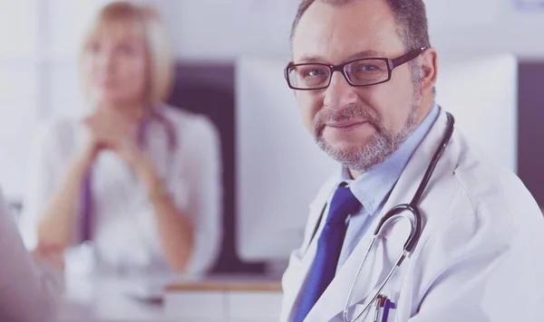 Lächelnde Ärzte an einem Arbeitsplatz im Krankenhaus — Stockfoto