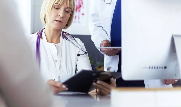 Medico donna seduto a tavola con computer portatile, al lavoro — Foto Stock