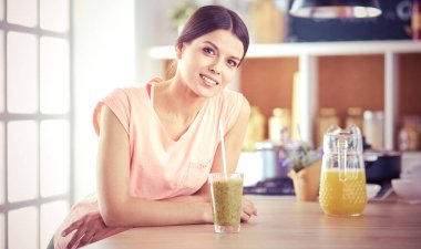 Mutfakta dijital tablet kullanan güzel genç bir kadın..