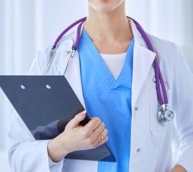 Üniformalı bir dosyayla gülümseyen kadın doktor