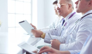 Tıbbi ekip masada oturup tartışıyor.