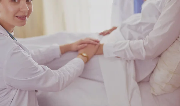 Médicos e enfermeiras a empilhar as mãos. Isolado em branco — Fotografia de Stock