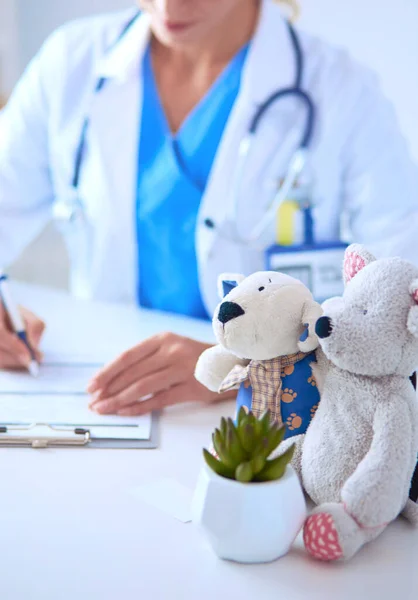 Bella giovane sorridente medico femminile seduto alla scrivania — Foto Stock