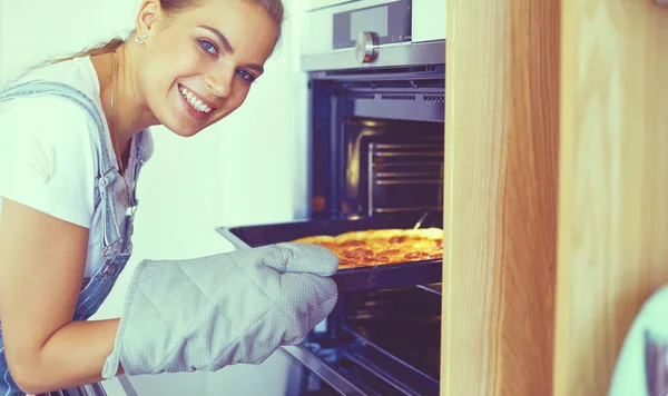 Gelukkig jong vrouw koken pizza thuis — Stockfoto