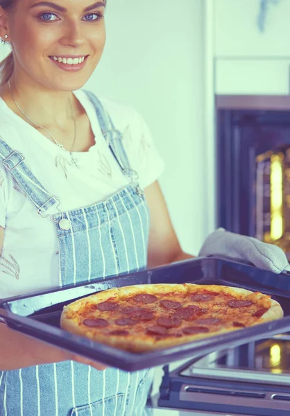 Glückliche junge Frau kocht zu Hause Pizza — Stockfoto