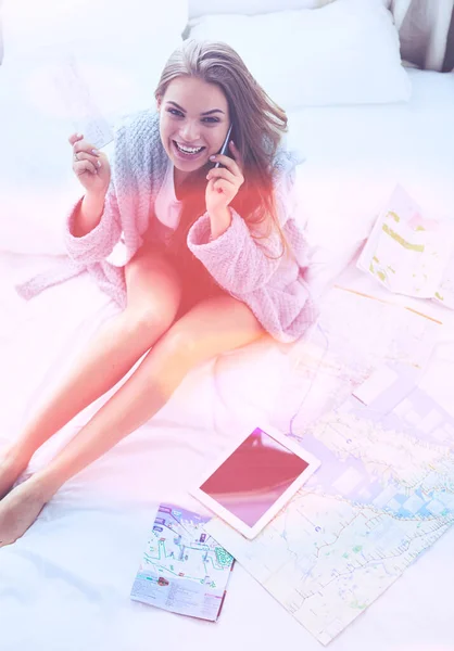 Entspannte junge Frau sitzt mit einer Tasse Kaffee und digitalem Tablet im Bett — Stockfoto