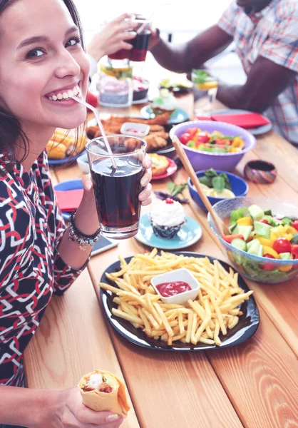 Vista superior do grupo de pessoas que jantam juntas enquanto estão sentadas à mesa de madeira. Comida na mesa. As pessoas comem fast food. — Fotografia de Stock