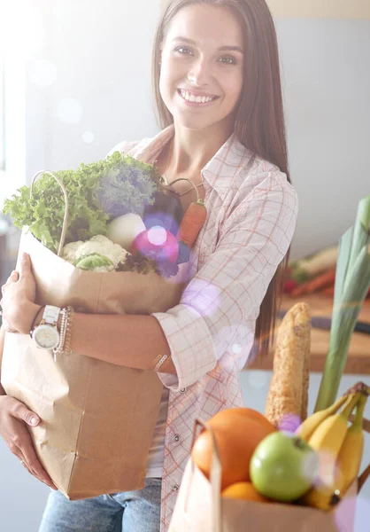 野菜の入った食料品の買い物袋を持っている若い女性。若い女性 — ストック写真