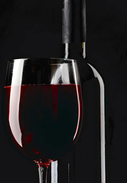 Silhouette of a bottle and glass of wine on a black background. — ストック写真