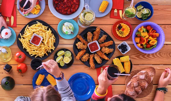 Personnes avec des boissons tout en étant assis à la table à manger — Photo