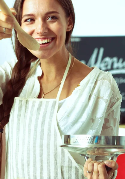 Кулинарная женщина на кухне с деревянной ложкой — стоковое фото