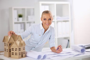 Ofisinde planları olan kadın mimarın portresi.