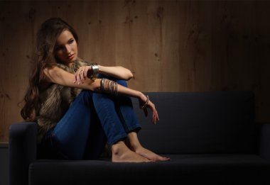 Mavi giyen siyah koltukta oturan zarif kadın portresi