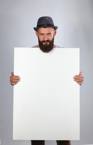Retrato de un joven con sombrero sosteniendo un blanco, aislado sobre blanco —  Fotos de Stock