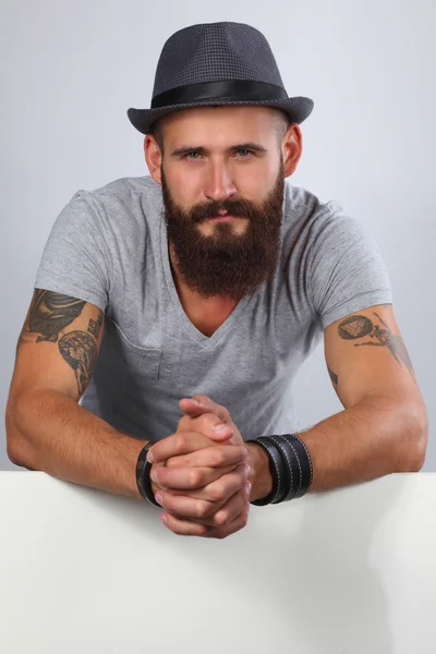 Portrait of young man in hat standing near blank, isolated on w — Stock Photo, Image