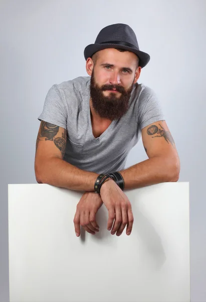 Portrait of young man in hat standing near blank, isolated on w — Stock Photo, Image