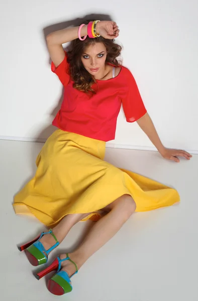 Young woman sitting on the floor, isolated in white background — Stock Photo, Image