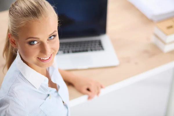 Attraente donna d'affari seduta su una scrivania con computer portatile in o — Foto Stock