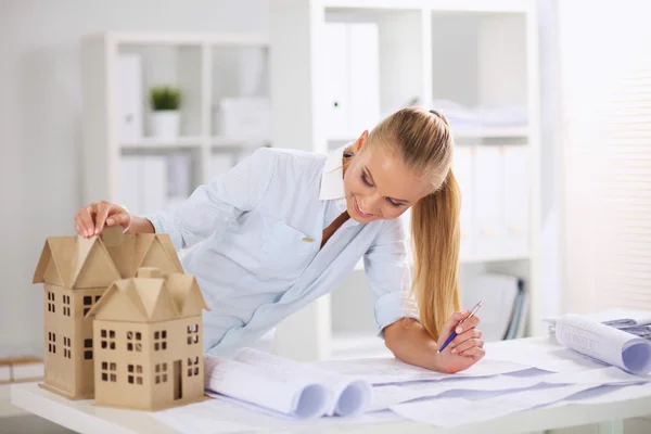 Retrato de una arquitecta con planos en el escritorio en la oficina —  Fotos de Stock