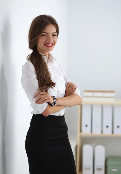 Attractive businesswoman with her arms crossed  standing in off — Stock Photo, Image