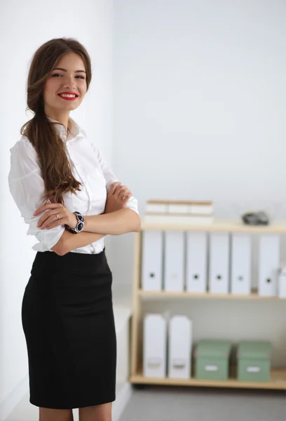 Attractive businesswoman with her arms crossed  standing in off — Stock Photo, Image