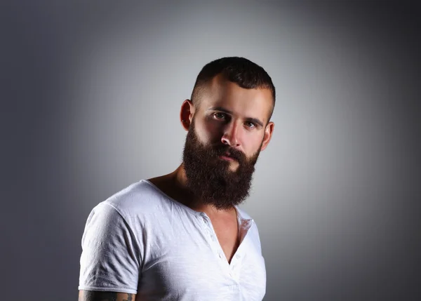 Retrato de hombre barbudo guapo de pie, aislado en bac gris — Foto de Stock