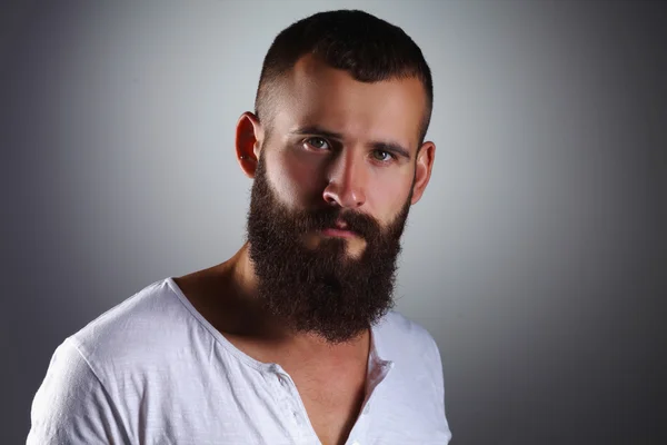 Retrato de hombre barbudo guapo de pie, aislado en bac gris — Foto de Stock