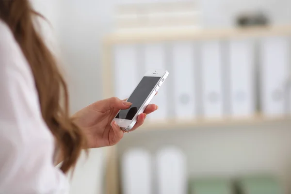 Empresária enviando mensagem com smartphone sentado no de — Fotografia de Stock