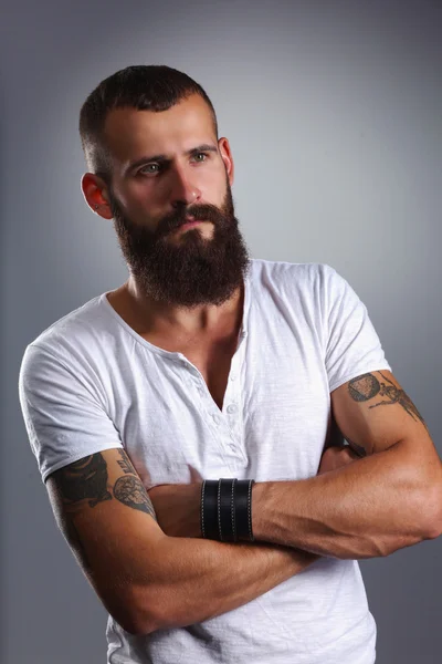 Portrait of handsome bearded man standing with crossed arms, is — Stock Photo, Image