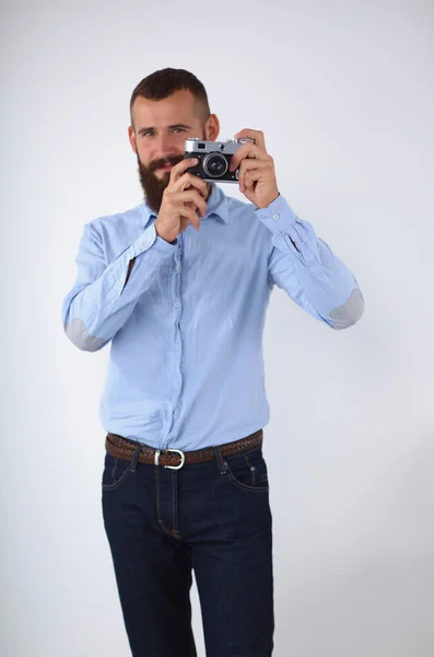 Joven barbudo enfocándose en ti con su cámara mientras está de pie — Foto de Stock