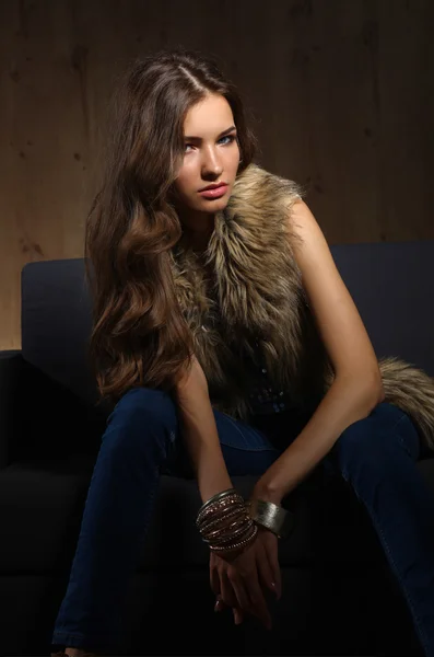 Portret van elegante vrouw zitten op Zwarte Bank draagt een blauw — Stockfoto