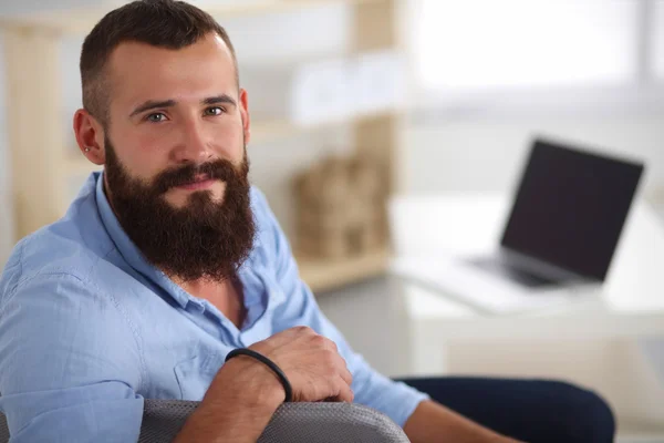 Jonge zakenman zit op stoel in functie — Stockfoto