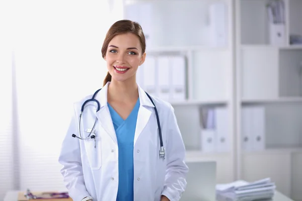 Retrato de una joven doctora con un abrigo blanco de pie en hosp —  Fotos de Stock