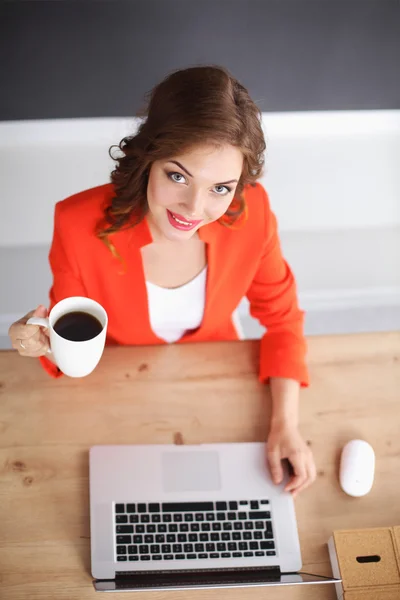 Mulher atraente sentada na mesa no escritório, trabalhando com laptop — Fotografia de Stock