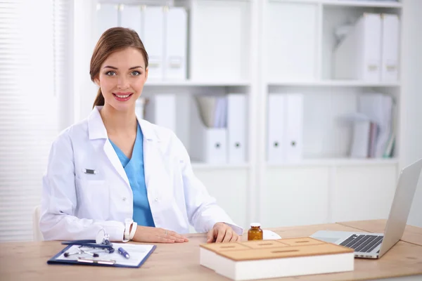 Medico donna seduto sulla scrivania e di lavoro un computer portatile in hospi — Foto Stock