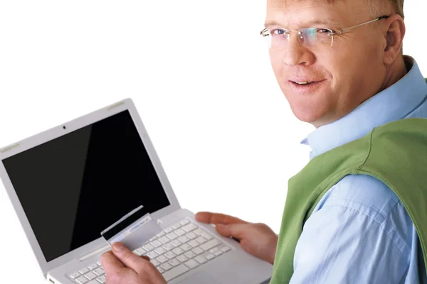 Homem sentado com um laptop, segurando cartão de crédito — Fotografia de Stock