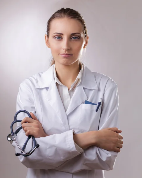 Retrato de close-up de uma médica com estetoscópio, isolado em cinza — Fotografia de Stock