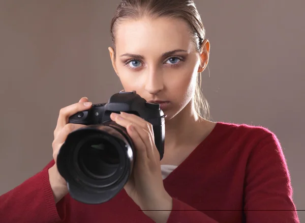 Mooie jonge vrouw met camera. geïsoleerd op grijs — Stockfoto