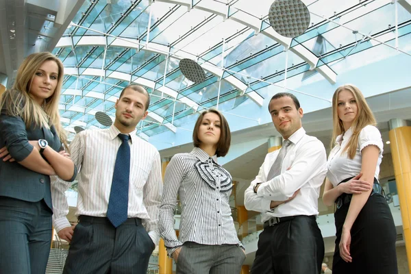 Successful business man standing with his staff in background — Stock Photo, Image