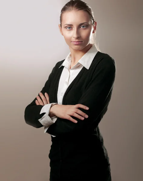 Portrait of beautiful business woman standing with folded arms, isolated on grey Stock Image