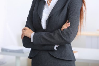 Ofiste kollarını kavuşturmuş duran iş kadını portresi.