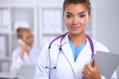 Hastanede üniformalı, gülümseyen bir kadın doktor.