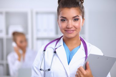 Hastanede üniformalı, gülümseyen bir kadın doktor.