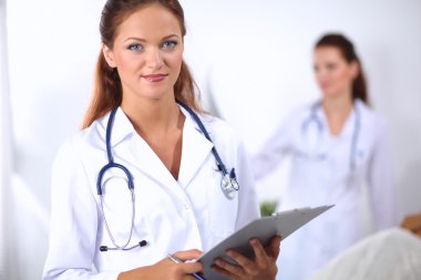 Hastanede üniformalı, gülümseyen bir kadın doktor.