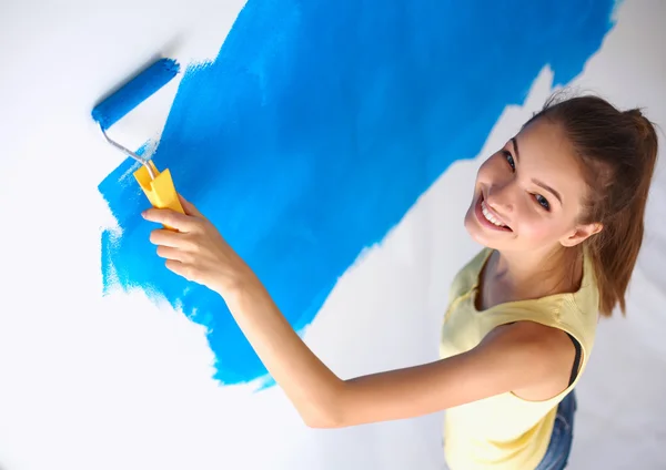 Happy beautiful young woman doing wall painting, standing on ladder — Stock Photo, Image