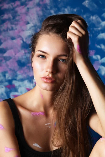 Young woman sitting near painting wall — Stock Photo, Image