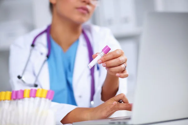 Woman researcher is surrounded by medical vials and flasks, isolated on white background — Stock Photo, Image